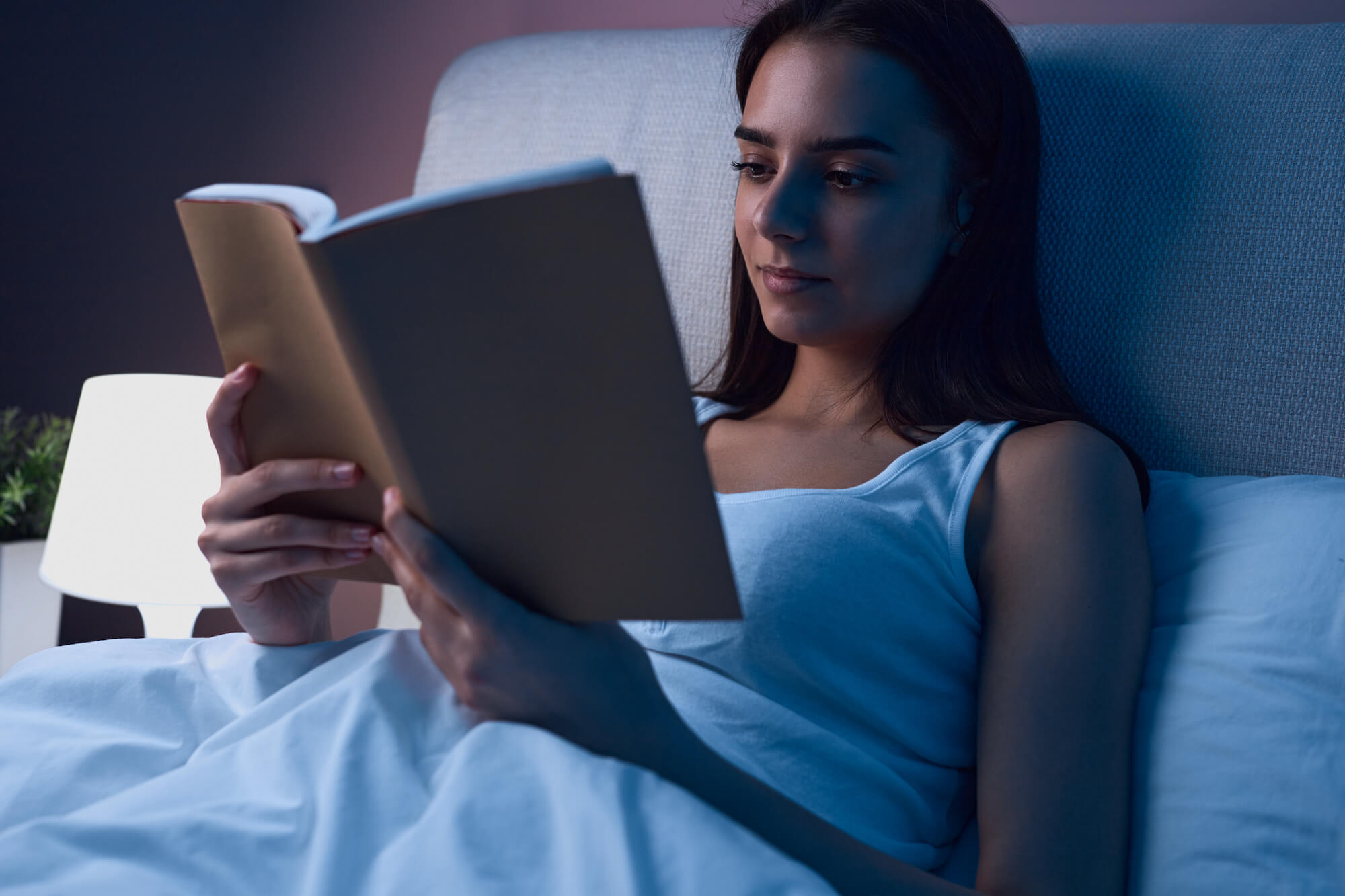 woman in bed reading carnivore diet books
